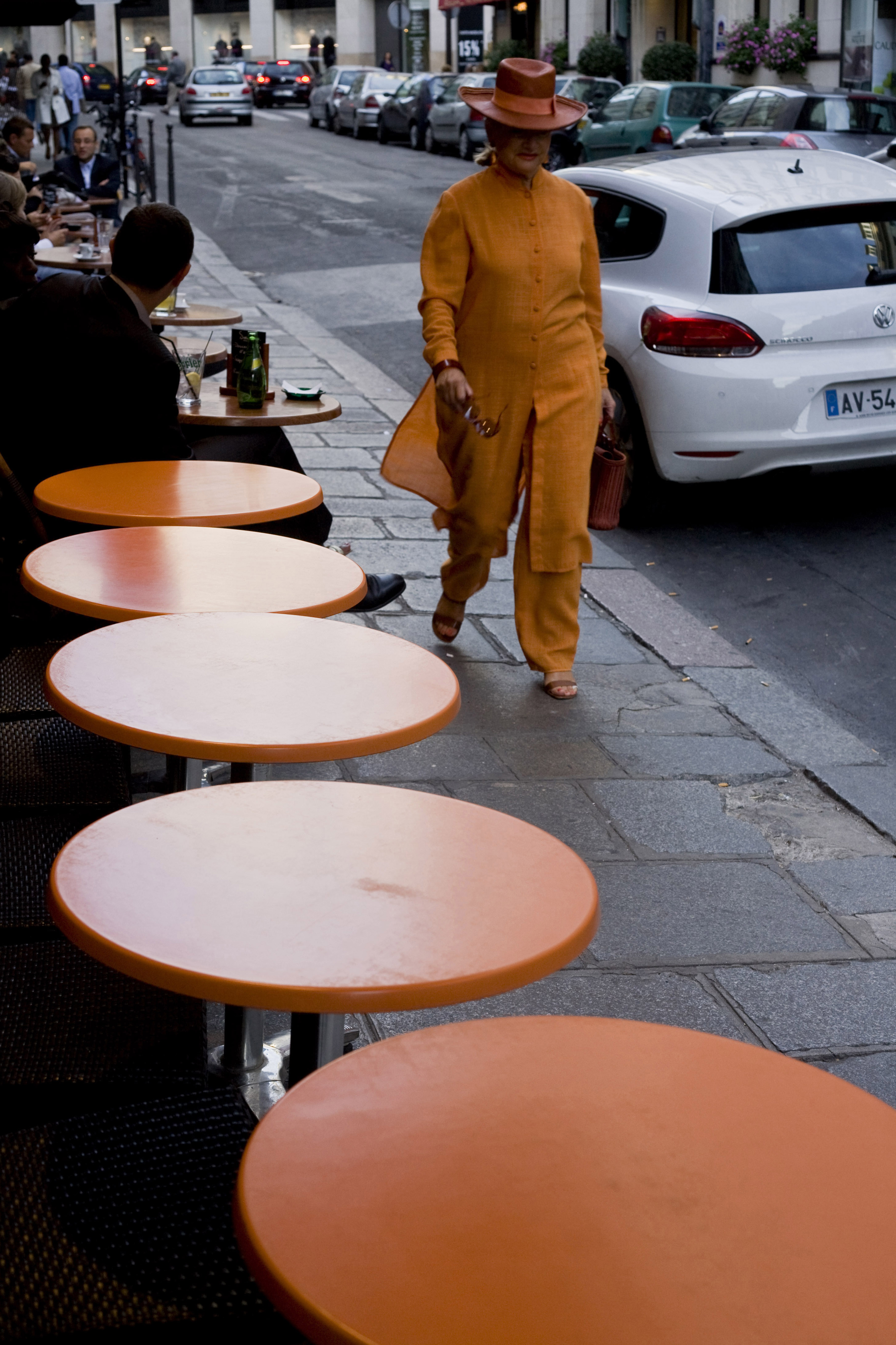 Dans le quartier du Faubourg St Honoré à Paris, llle quartier du luxe et de la haute couture, une élégante passe devant les tables d'un café.