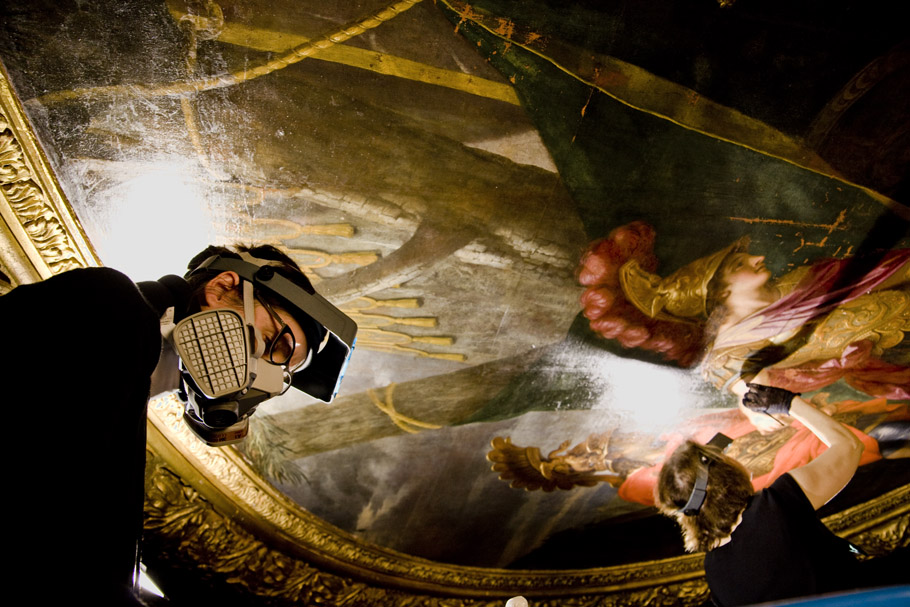 Une restauratrice au travail sur le plafond